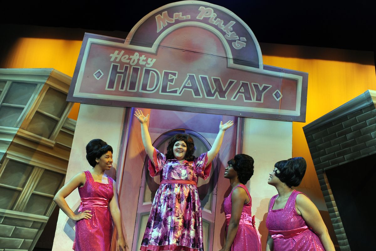 Tracy Turnblad, center, played by Lindsey Hedberg, is surrounded by The Dynamites, a girl group played by, from left, Yudith Burton, Oyoyo Joi Bonner and Antonia Darlene in a scene from the Coeur d