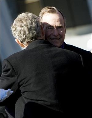 Former President George H. W. Bush, right, hugs his son President Bush following the commissioning ceremony for the USS George H.W. Bush (CVN77) aircraft carrier in Norfolk, Va.  (The Spokesman-Review)