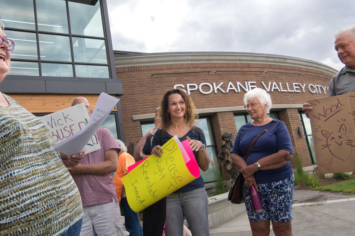 Leilani Delong, left, with Valley Indivisible Progressives, leads chants with Petra Hoy, center left, Hallie Koyukuk, center right, and Mike Foley, right, outside Spokane Valley City Hall following Mayor Rod Higgins’ abrupt ousting of Council Member Ben Wick from the Spokane Regional Transportation Council Board and the council