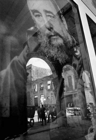 
A Havana street is reflected on an image of Fidel Castro in a store window Monday. Cuba is gearing up for a May Day march today with several million workers.
 (Associated Press / The Spokesman-Review)