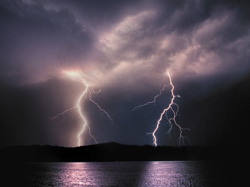 Traveling some 50,000 miles per second duo lightning bolts streak from energy charged clouds and strike the horizon near Newman Lake in Eastern Washinton.   (Brian Plonka/The Spokesman-Review)