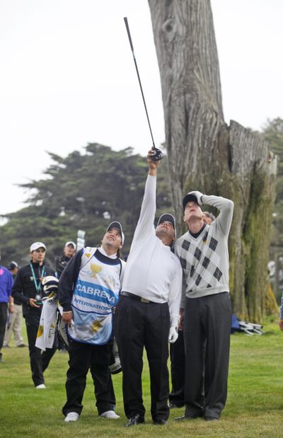 Angel Cabrera, center, is helped by caddie Angel Cabrera, Jr., left, and Jim Furyk after losing his ball in a tree on the 13th hole.  (Associated Press / The Spokesman-Review)