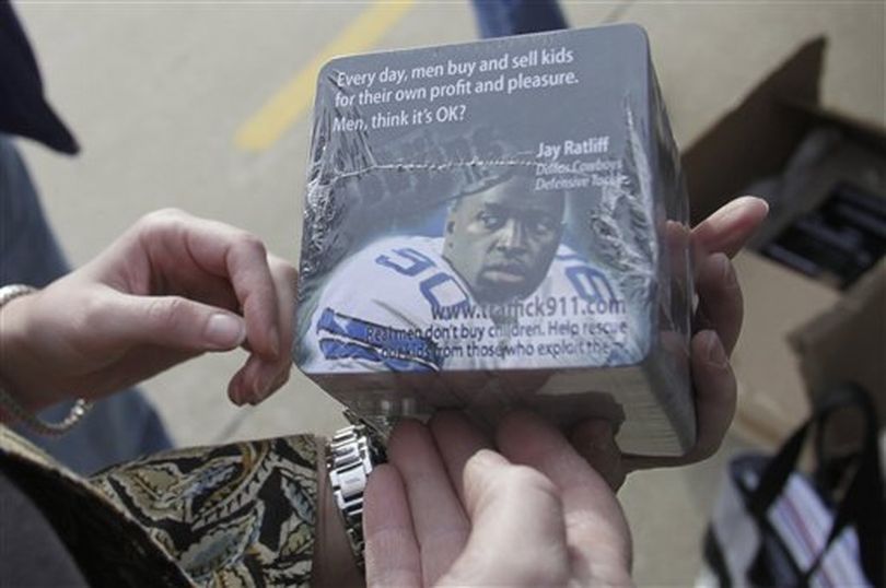 In this photo made Thursday, Jan. 27, 2011, anti-sex trade advocate Jackie Edmonds holds anti-trafficking awareness coasters that her group will ask restaurants to use near the Super Bowl site in Arlington, Texas. Cities that host the big game often attract a bustling sex trade, and this year Texas authorities and advocacy groups are stepping up their anti-prostitution efforts, especially where young girls are concerned. (Lm Otero /  (AP Photo/LM Otero))