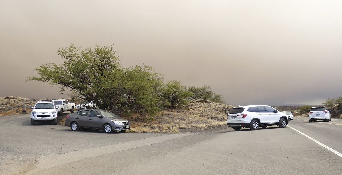 Vehicles turn onto Queen Kaahumanu Highway from an emergency access route opened after residents and visitors lodging in the Waikoloa Village area of Hawaii were ordered to evacuate as a wildfire threatened the South Kohala town Sunday, Aug. 1, 2021.  (Chelsea Jensen)