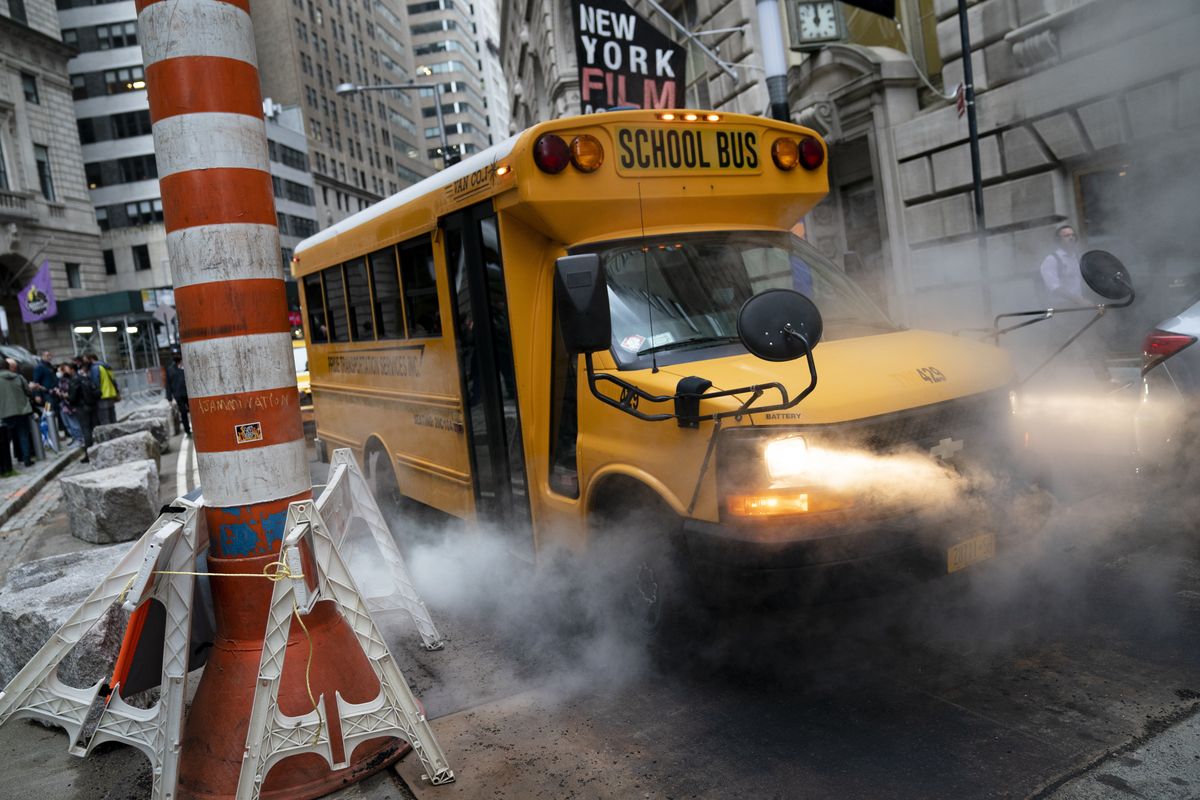 A school bus passes over a steam vent on a morning route Monday in the Manhattan borough of New York.  (John Minchillo)