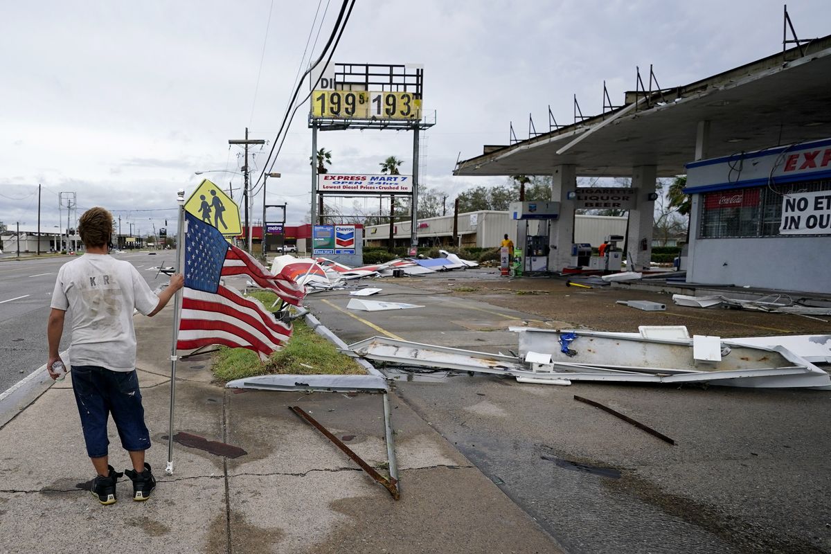 Dustin Amos walks near debris at a gas station on Thursday, Aug. 27, 2020, in Lake Charles, La., after Hurricane Laura moved through the state.  (Gerald Herbert)