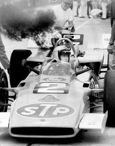 In this May 8, 1969 photo, Mario Andretti sits calmly in his car as his crew works to put out a fire that blistered some paint, at the Indianapolis Motor Speedway in Indianapolis. Mario Andretti sees the reminders of 1969 everywhere he turns these days. His face, his race-car number, even that familiar STP logo appear on an endless array of memorabilia at this year’s Indianapolis 500. He has own street, his own badge and even his own store. It’s all part of the golden anniversary of the first and only 500 win for one of the greatest drivers in racing history. (Associated Press)