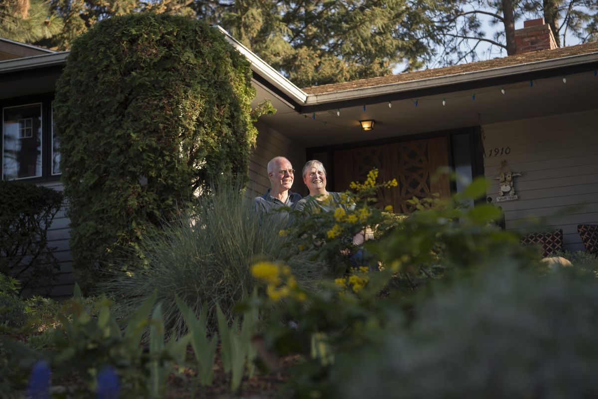 Lars Hendron and Kris Moberg-Hendron pose for a photo in their front yard. Moberg-Hendron removed her front lawn, replacing it with  drought-tolerant and native plants. (Tyler Tjomsland / The Spokesman-Review)