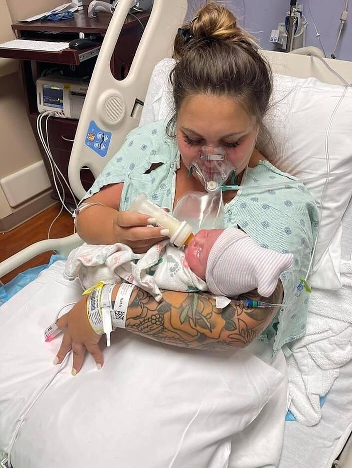 This July 27, 2021, photo provided by Melissa Syverson shows West Melbourne resident Kristen McMullen, 30, feeding her newborn daughter, Summer, at Holmes Regional Medical Center in Melbourne, Fla. Kristen only got to hold Summer for a few moments after giving birth via emergency C-section. The mother, who had COVID-19, was then taken to the ICU, where her condition worsened. She died on Aug. 6, 2021, 10 days after her little girl was born.  (Melissa Syverson)