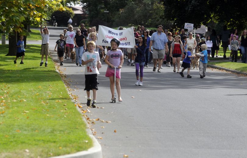 Families and friends of Jefferson Elementary march in a “Move It for the Kids” walk on Sunday. (J. Bart Rayniak)