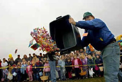 
Rick Ruggles throws candy onto the grass while hundreds of kids wait to pick it up at the First Assembly of God Church's annual Easter party Saturday. 
 (Jesse Tinsley / The Spokesman-Review)