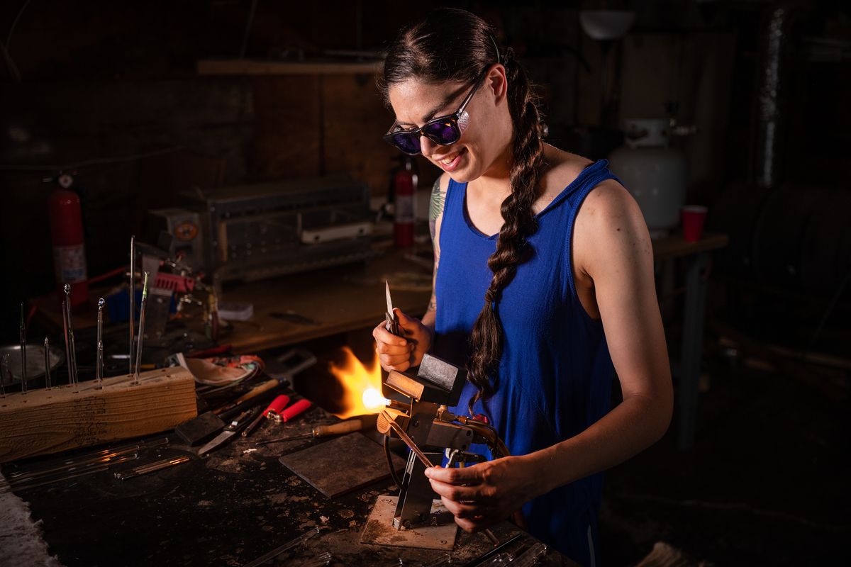 Glass artist Maayan Gordon creates a glass pendant using a tabletop torch in her South Hill garage studio on Aug. 25. (Colin Mulvany/The Spokesman-Review)