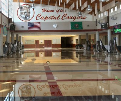 The Capital High School mascot is reflected on standing water in the school’s lunch area after a 2,500-square-foot section of the roof collapsed early Christmas Day under the weight of snow, ice and water from recent storms in Olympia. (Associated Press / The Spokesman-Review)