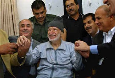 
In this picture released by the Palestinian authority, Palestinian leader Yasser Arafat holds hands with Tunisian, Jordaninan and Egyptian doctors Thursday at his compound.In this picture released by the Palestinian authority, Palestinian leader Yasser Arafat holds hands with Tunisian, Jordaninan and Egyptian doctors Thursday at his compound.
 (Associated PressAssociated Press / The Spokesman-Review)