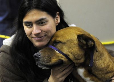 Charee Discenza and  service dog Denver wait in line at the Christmas Bureau at the Spokane County Fair and Expo Center. Discenza has three children, ages 7, 8 and 9.   (Dan Pelle / The Spokesman-Review)