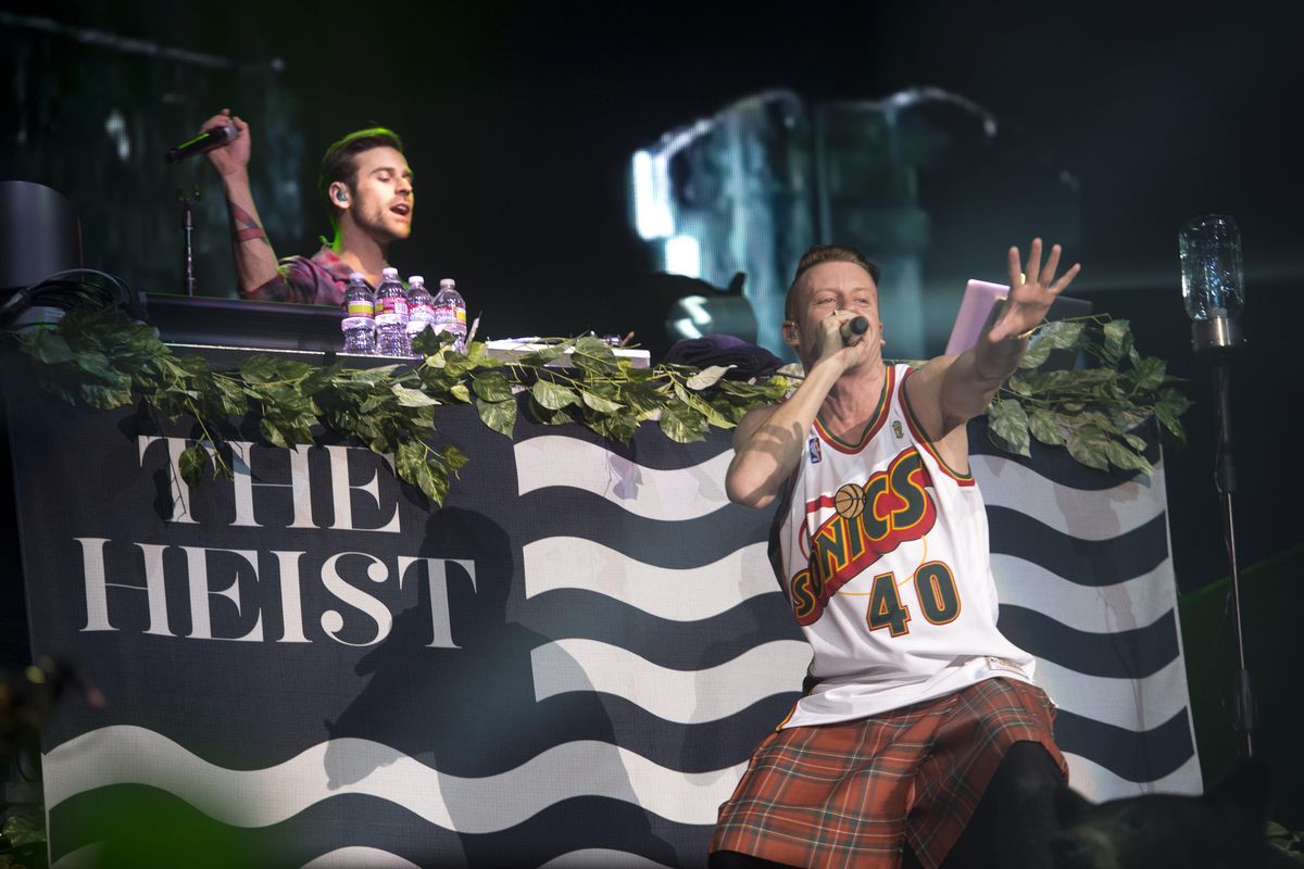 DJ Ryan Lewis, left, who grew up in Spokane, keeps the beat behind the DJ console while rapper Macklemore holds sway in front at a concert at the Spokane Arena on Wednesday, Oct. 23, 2013. Lewis and Macklemore brought their hit-laden show to the Spokane audience of 8,000. (Jesse Tinsley / The Spokesman-Review)