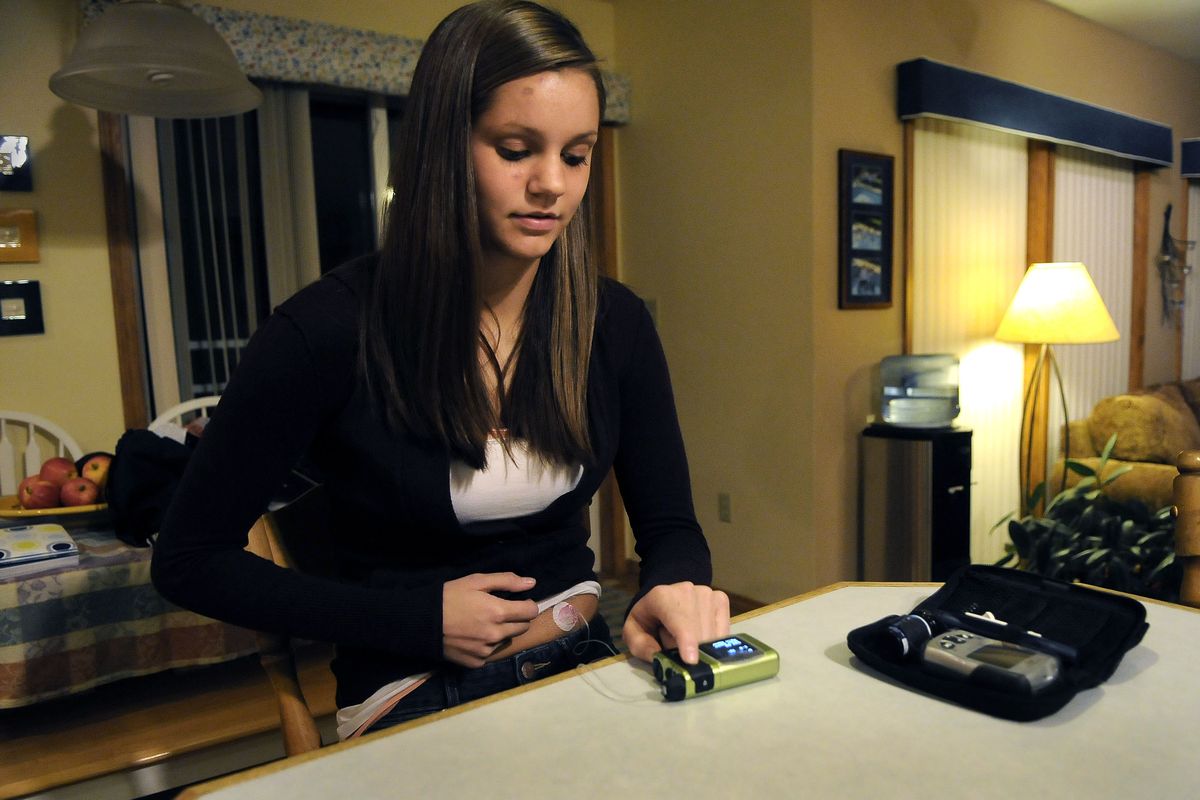 Megan Davis checks her insulin pump after taking her blood sugar level. The Ferris High School sophomore was diagnosed at age 9 with Type 1 diabetes.  (Dan Pelle)