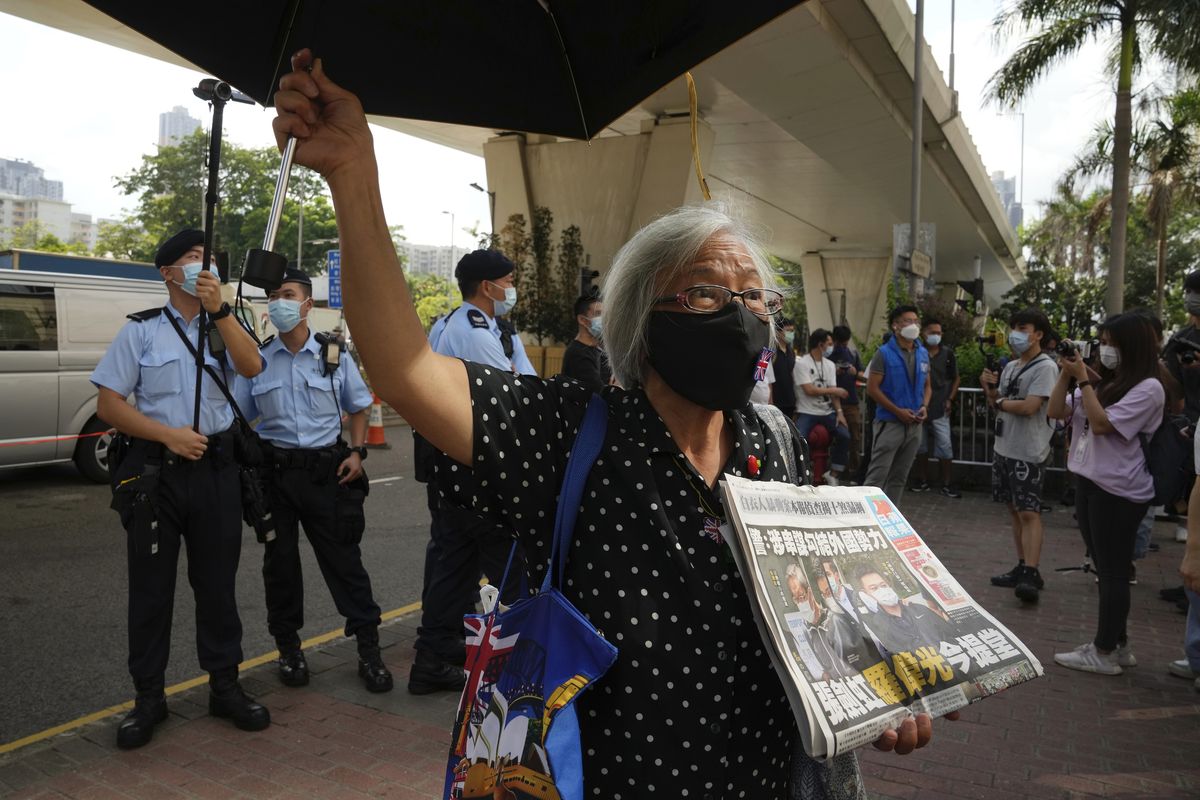 A pro-democracy activist holding a copy of Apple Daily newspaper protests outside a court in Hong Kong, Saturday, June 19, 2021, to demand to release political prisoners. The top editor of the Hong Kong