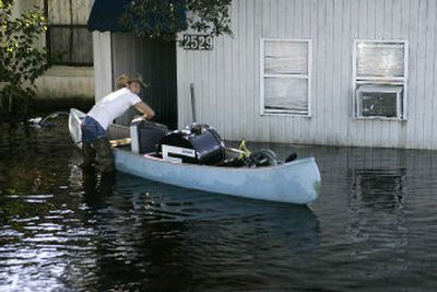 
Jordan Milton loads some of a friend's belongings into a canoe from a flooded home in Cocoa, Fla., in 2005.  
 (File / Associated Press / The Spokesman-Review)