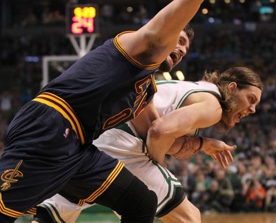 Cavaliers forward Kevin Love, left, is pulled by the arm by Celtics center Kelly Olynyk in Sunday’s game. (Thomas Ondrey)