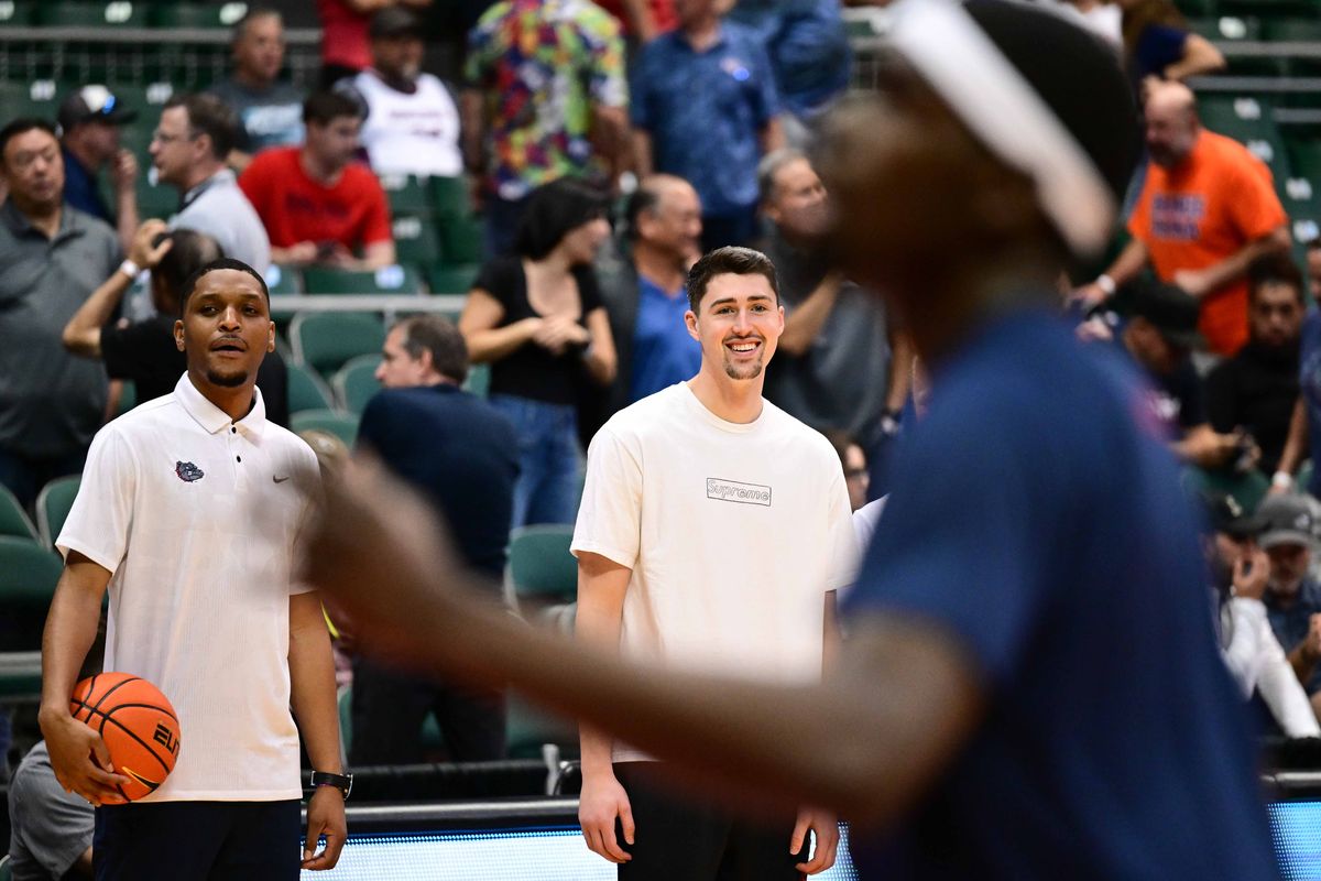 Gonzaga guard Steele Venters, center, who is out for the season with a knee injury, laughs with assistant coach Zack Norvell Jr. as they watch warm-ups Nov. 20 in Honolulu.  (Tyler Tjomsland/The Spokesman-Review)