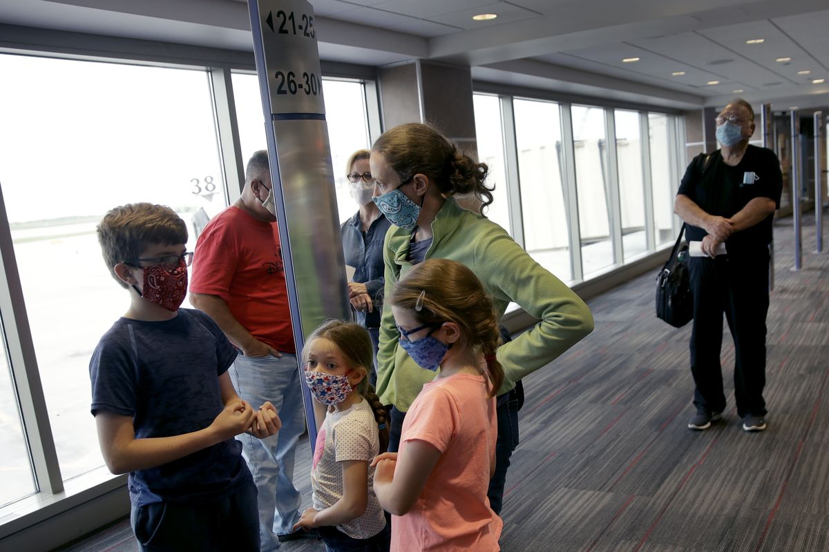 FILE - People wearing masks wait to board a Southwest Airlines flight at Kansas City International airport in Kansas City, Mo., in this May 24, 2020, file photo. Governments and businesses are scrambling to change course following new federal guidance calling for the return of mask wearing in virus hot spots amid a dramatic spike in COVID-19 cases and hospitalizations nationwide. Nevada and Kansas City were among the locations that moved swiftly to re-impose indoor mask mandates following Tuesday’s, July 27, 2021, announcement from the Centers for Disease Control and Prevention.  (Charlie Riedel)