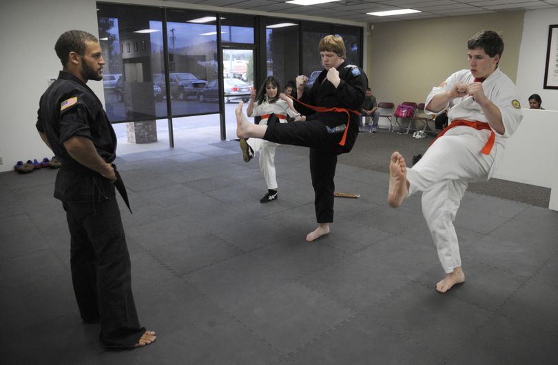 Instructor Adam Smith teaches karate to autistic students, left to right, Tessa Merritt, 17, Matthew Pretz, 17, and Paul McKinley, 18, at Tazmanian Martial Arts in Spokane Valley on Tuesday. (Colin Mulvany)