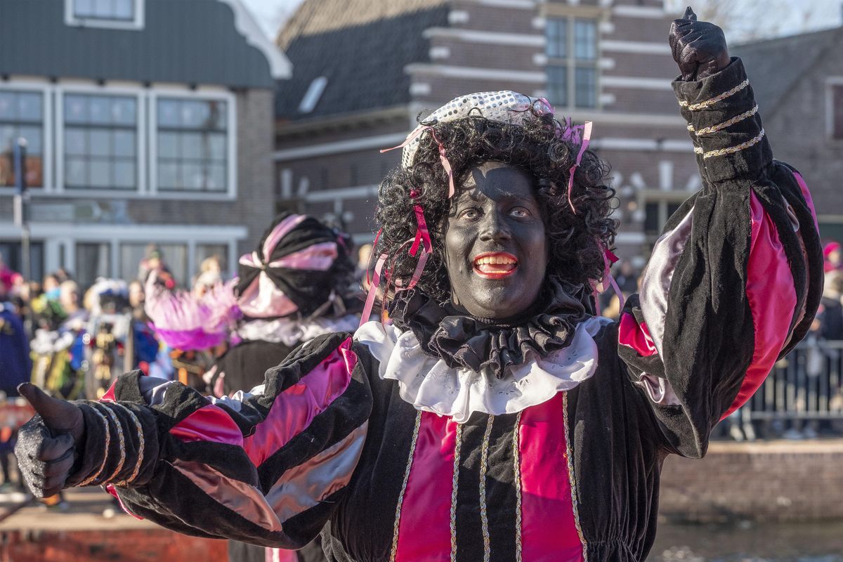 A Black Pete interacts with children during the arrival of Sinterklaas in Monnickendam, Netherlands, on Saturday, Nov. 17, 2018. White people often daub their faces with black paint when they dress up to play the character. Opponents say such depictions of Black Pete promote racist stereotypes. Supporters defend the sidekick of Sinterklaas, the white-bearded, red-robed Dutch version of St. Nicholas, as a traditional children’s character. (Patrick Post / AP)