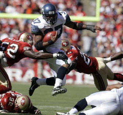 
Shaun Alexander jumps between San Francisco's Patrick Willis, left, and Mark Roman for a third-quarter gain. Associated Press
 (Associated Press / The Spokesman-Review)