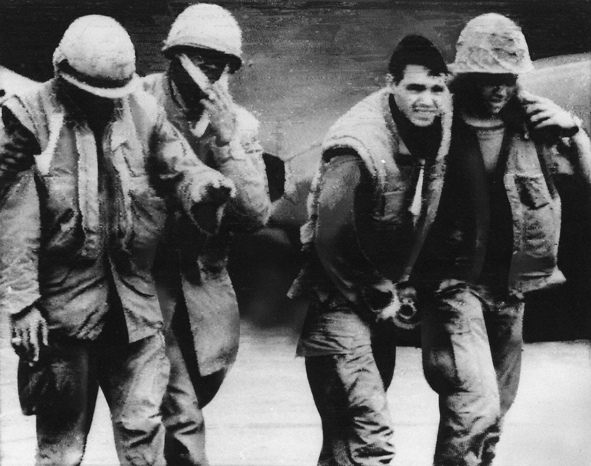 In this Feb. 5, 1968, file photo, a blinded U.S. Marine, left, holds his hand out in front of him as he is led by a wounded comrade from his evacuation helicopter that brought them from Hill 861 to the main Marine base at Khe Sanh, South Vietnam. Another wounded leatherneck is helped by a hospital corpsman at right. The Marines were wounded during a 3 1/2-hour assault by North Vietnamese troops. Early on the morning of Jan. 31, 1968, as Vietnamese celebrated the Lunar New Year, or Tet as it is known locally, Communist forces launched a wave of coordinated surprise attacks across South Vietnam. (AP)