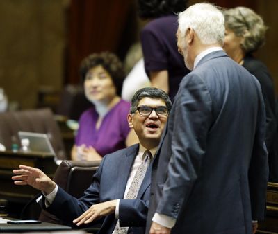 Rep. Javier Valdez, D-Seattle, left, talks with Rep. Gerry Pollet, D-Seattle, right, at the Capitol after the House approved a paid family leave program Friday, June 30, 2017, in Olympia. The Washington Legislature on Friday approved a paid family leave program that offers workers paid time off for the birth or adoption of a child or for the serious medical condition of the worker or the worker's family member. (Ted S. Warren / AP)