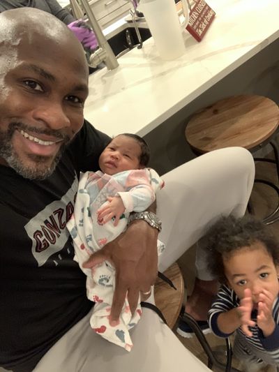 Gonzaga assistant men’s basketball coach Roger Powell Jr. holds his newborn daughter, Faith, with 18-month-old son Gabriel not far away.  (Courtesy of Roger Powell)