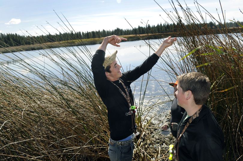 Cody Hoseth, 16, of Mead, demonstrates to his stepbrother, Joey Zemke, 13, and Zack Sawchuk, 12,  behind Zemke, how difficult a shot it would be if waterfowl landed to the right of their hunting blind at Turnbull National Wildlife Refuge.  (Dan Pelle)