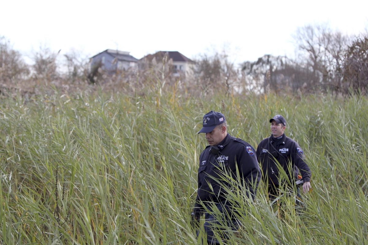 Police officers wearing wet suits leave a site where the body of a 2-year-old child killed during Superstorm Sandy was discovered in Staten Island, New York, Thursday, Nov. 1, 2012. Brandon Moore, 2, and Connor Moore, 4, were swiped into swirling waters as their mother tried to escape her SUV on Monday amid rushing waters that caused the vehicle to stall during Superstorm Sandy.  Police said the mother, Glenda Moore, was going to her sister