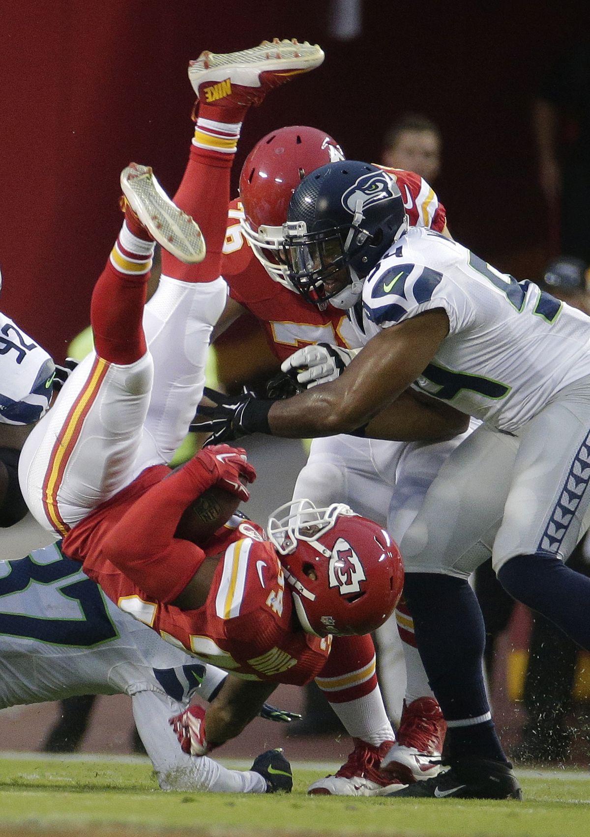 Kansas City Chiefs running back Knile Davis (34) is upended by Seattle Seahawks free safety Dion Bailey (37) and linebacker Bobby Wagner (54) during the first half. (AP)