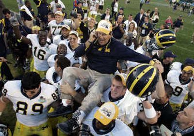 
Associated Press Michigan players carry coach Lloyd Carr after upsetting No. 9 Florida. Carr announced his retirement on Nov. 19.
 (Associated Press / The Spokesman-Review)