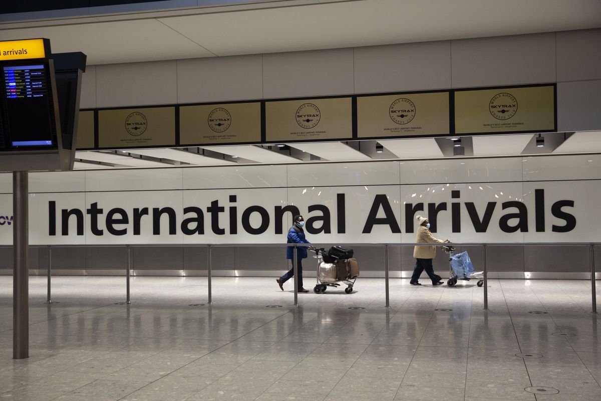 Arriving passengers walk past a sign in the arrivals area at Heathrow Airport on Jan. 26 in London. A terminal at Heathrow Airport mothballed because of the coronavirus pandemic has reopened Tuesday, June 1 for passengers arriving from high-risk countries. Britain has barred travelers from a “red list” of 43 coronavirus hotspots including India, Brazil, Turkey and South Africa. U.K. nationals and residents who return from those countries face a mandatory 10-day supervised quarantine in a hotel.  (Matt Dunham)