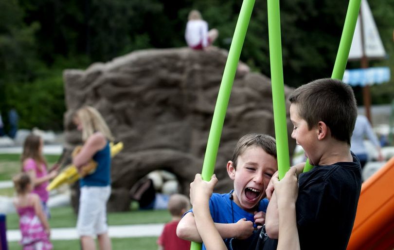 Seven-year-old Cason Sperber, center, and Kyle Johnson,7 made good use of the newly opened playground area at McEuen Park in Coeur d'Alene on Friday, May 23, 2014. (Kathy Plonka)