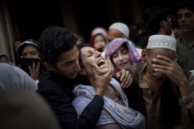 Relatives of Raheel Fayz, a police officer killed during an assault on a Pakistani police academy Monday, react during his funeral in Lahore, Pakistan, on Tuesday.  (Associated Press / The Spokesman-Review)