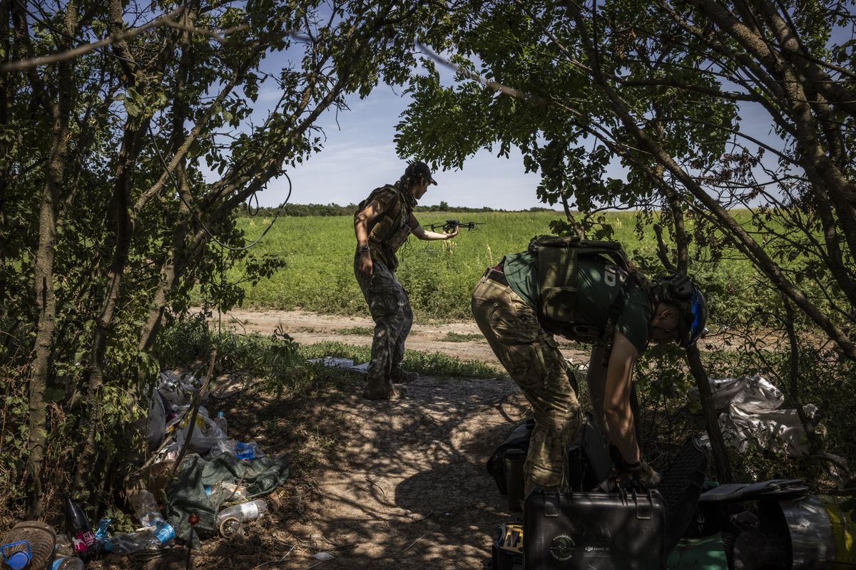 A soldier catches a surveillance drone Friday near the village of Mala Tokmachka, in southeastern Ukraine.   (Ed Ram/For The Washington Post)