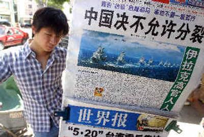 
A man looks at newspapers including one with a headline reading 