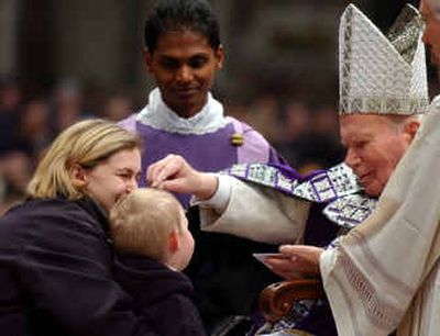 
 Pope John Paul II smudges ashes on the head of a child during a ceremony in St. Peter's Basilica at the Vatican to mark the start of Lent last year.
 (File/Associated Press / The Spokesman-Review)
