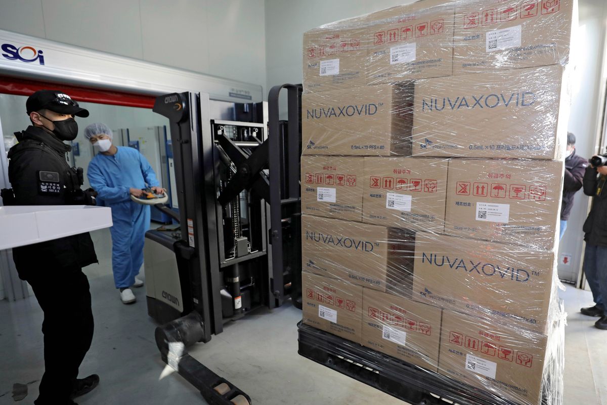 FILE - A worker moves boxes carrying Novavax