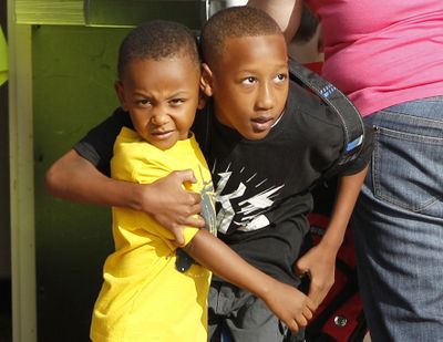 Cam'ron Richardson, right, hugs his brother Anthony as he heads in for the first day of school at Plaza Towers Elementary School in their temporary location at Central Jr. High School in Moore, Okla., on Friday. (Associated Press)