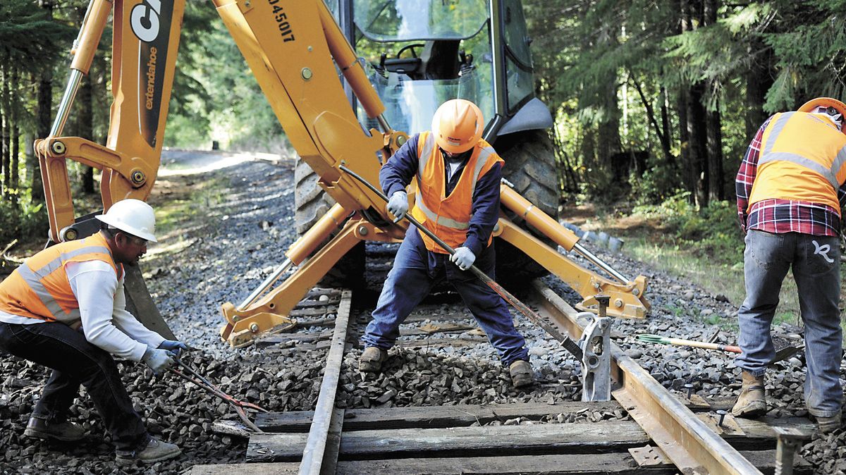 Workers from Balfour Beatty Rail Inc. build a new crossing on the Coos Bay Rail Link near Noti, Ore., on Oct. 16. The line was shut down in 2007 and purchased by the Oregon International Port of Coos Bay in 2009. Service to some customers resumed in 2011, and construction work continues on the tracks. (Associated Press)