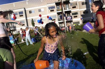 
Deanna Maynor, 11, center, gets soaked by Carol Wolfer, left, and Candace Pichette, 14, during the Night Out party at Catherine Johnson Court apartments Tuesday. 
 (Holly Pickett / The Spokesman-Review)