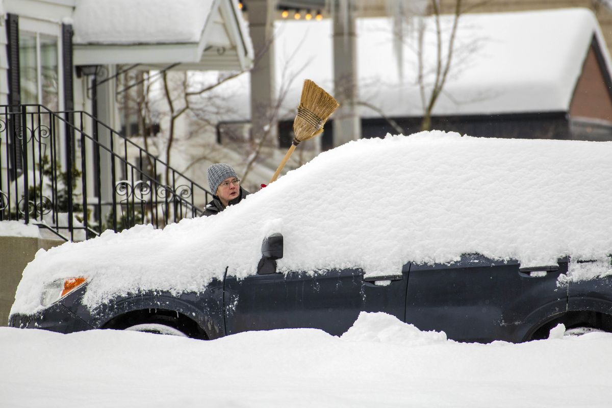 Pat Gunderson clears the previous night’s snowfall off her car at 27th Avenue and Tekoa Street on Spokane’s South Hill on Tuesday Feb. 12, 2019. (Colin Mulvany / The Spokesman-Review)