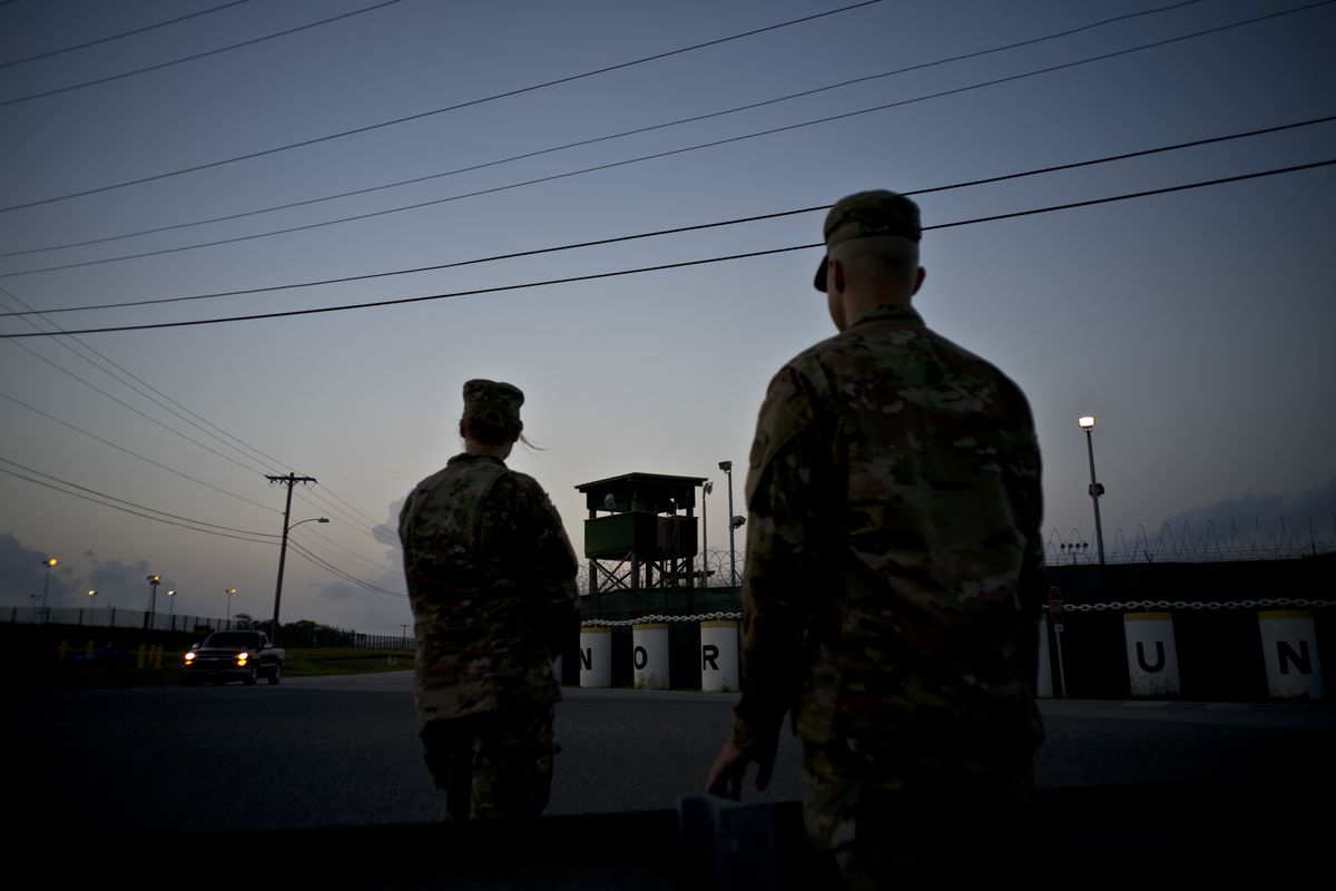 In this June 5, 2018 photo, reviewed by U.S. military officials, troops stand guard outside Camp Delta at the Guantanamo Bay detention center, in Cuba. The 20th anniversary of the first prisoners