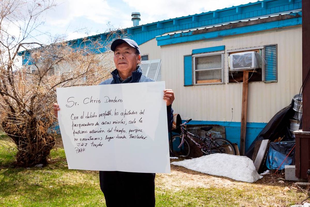 Enrique De la Cruz holds a sign in front of his mobile home asking a developer to give him and his neighbors at J&J Trailer Park in Blaine County more time to relocate. They are supposed to be out by May 31.  (Sarah A. Miller)