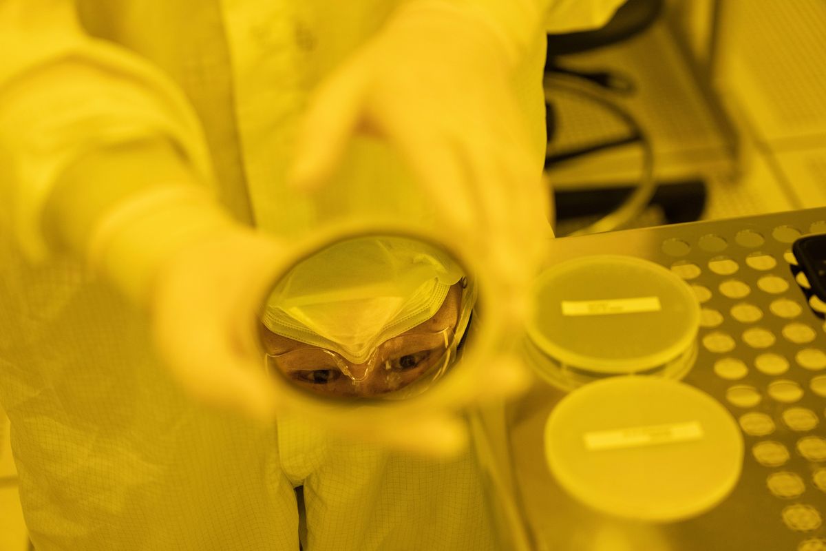 Joon Hyeong Park, an instructor at Purdue University, is reflected in a set of chips manufactured at the Birck Nanotechnology Center.  (AJ Mast/Washington Post )
